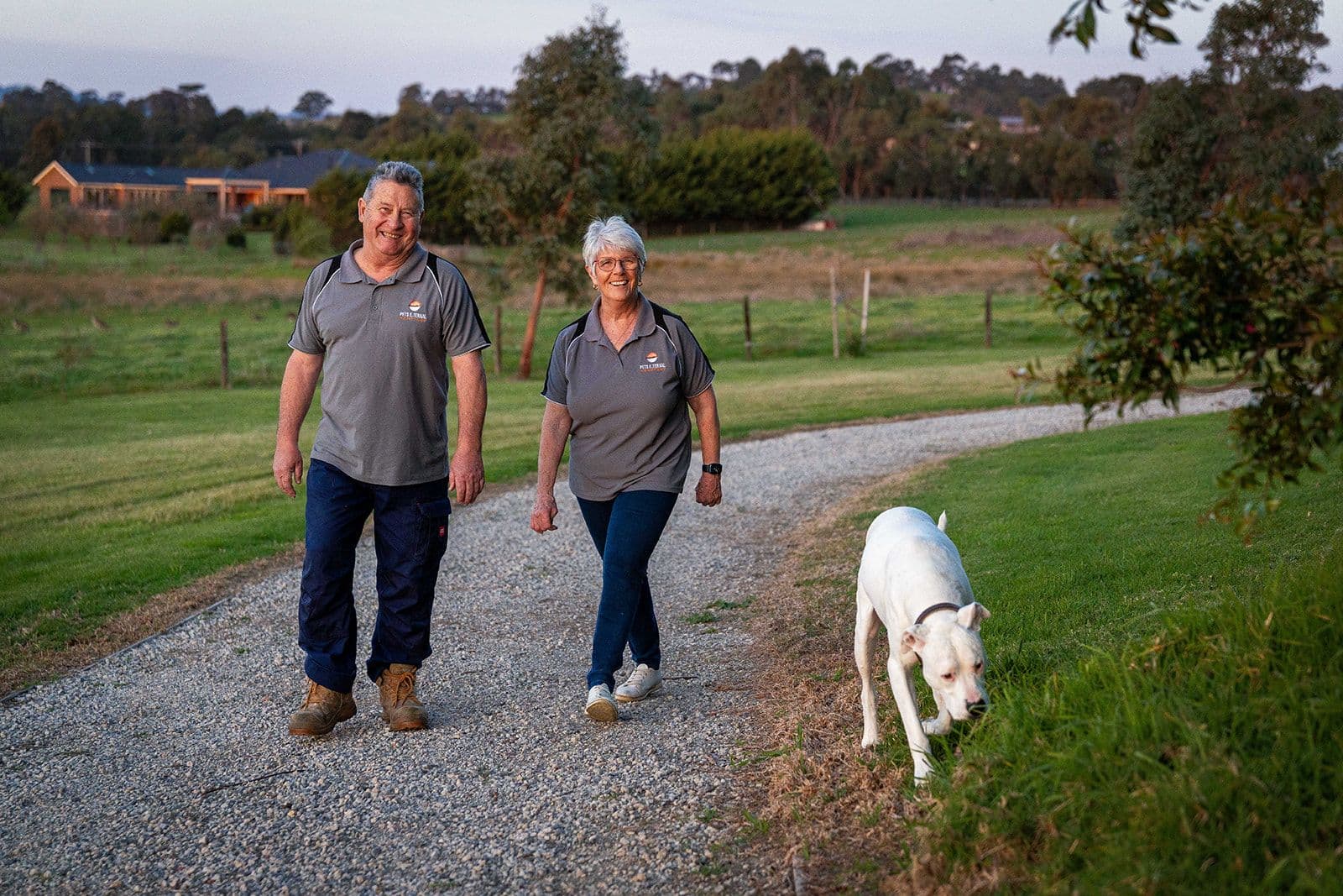 Terry and Karen walking through the grounds with a dog